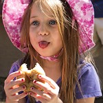 Alli sticking her tongue out at Aaron between bites of apple doughnut.